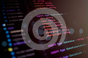 Close-up view of programming code on a computer screen showing TypeScript interface structure for web development and software