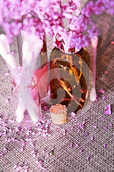 Close Up view of purple cosmetics bottles with cotton buds on the desk