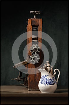 Close up view of a purple DahliaStill life of antique vintage washing wringer, pitchur and clothespins.