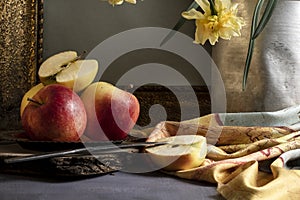 Close up view of red apples and bloomed daffodils on table, vintage still life, art interior design