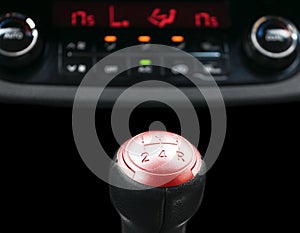 Close up view of a red gear lever shift, manual gearbox, car interior details.