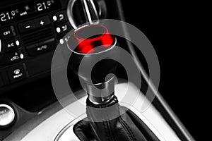 Close up view of a red gear lever shift. Manual gearbox. Car interior details. Car transmission. Soft lighting. Abstract view. Car