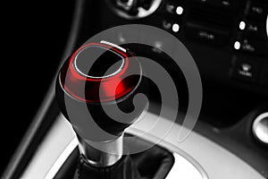 Close up view of a red gear lever shift. Manual gearbox. Car interior details. Car transmission. Soft lighting. Abstract view. Car