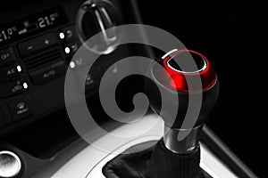 Close up view of a red gear lever shift. Manual gearbox. Car interior details. Car transmission. Soft lighting. Abstract view. Car