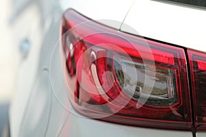 Close up view of red rear tail light of white car