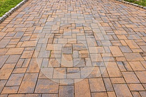 A close-up view of the red stone pathway alongside the lawn.