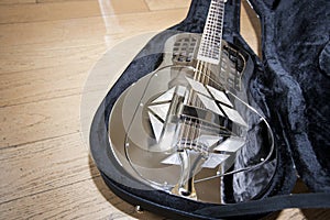 Close-up view of resonator guitar in carry case photo