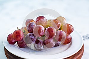 Close up view of ripe grapes on white plate