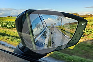 Close up view of the road in the side mirror of the car