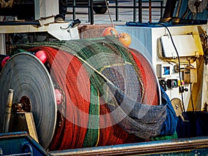 close up view of rolled up fishing net on a winch aboard a small fishing boat