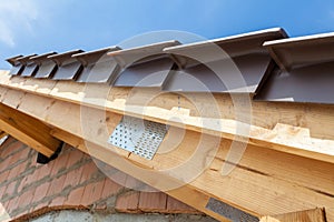 Close-up view of roof detail with wooden rafters and roof tiles. New house under construction.