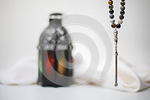 Close-up view of Rosary beads with blurred lantern in background.