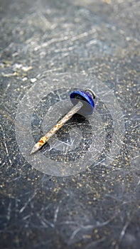 Close up view of rusty dull nail on the black scratches surface background