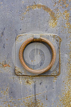 Close-up view of rusty knocker on a rusty metal door. The texture of metal and rust is visible. Georgia