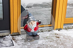 Close-up view of Santa Claus standing in front of entrance door.