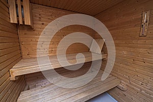 Close up view of sauna room interior. Wooden walls and seats.