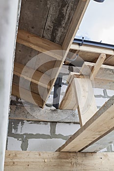 close up view of scaffolding and house under construction with grey folding roof on waterproofing layer