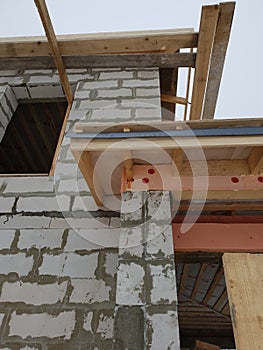 close up view of scaffolding and house under construction with grey folding roof on waterproofing layer