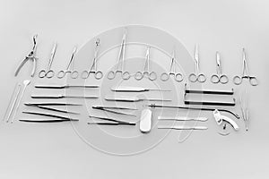 Close-up view on scalpels, scissors, trocars, forceps and clamps grey background