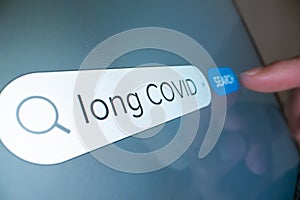 Close-up view of searching information on Long COVID on internet