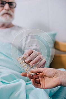 Close-up view of senior patient taking medications from