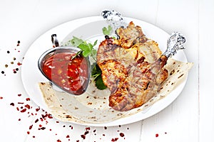 Close up view on served cooked on the grill chicken. shashlik or barbecue meat on pita. Shish kebab, traditional georgian cuisine