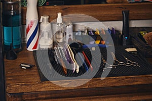 Close-up view of set of professional barber tools on wooden shelf in barbershop