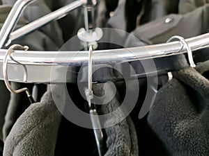 Close up view of several hangers with jackets on them hanging on a clothes rail