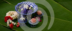 Several Thai traditional dessert serving on porcelain with garland jasmine decorated on banana leaves