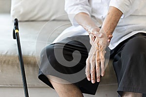 Close up view on the shaking hand of the senior woman,symptom of resting tremor or parkinson`s disease,old elderly patient holdin