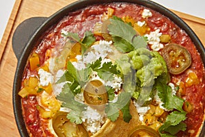 Close up view of Shakshuka dish in a pan with spicy sauce from tomatoes.