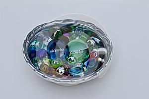 Close up view of a silver metal bowl containing decorative glass stones