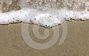 Close-up View of a Small Smooth Wave on a Beach in the Evening