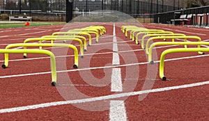 Close up view of small yellow hurdles in two lanes on a track