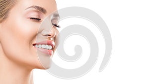 Close up view of a smiling woman with closed eyes over white background. Dental and skin care concept.