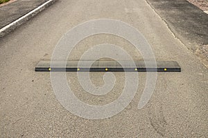 Close up view of speed bump on street road. Landscape view background. Europe.