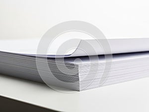 Close up view of stack of blank white paper sheets on a white surface