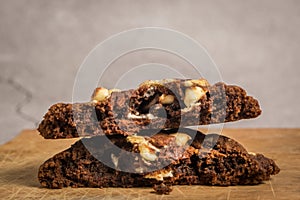 Close up view of stack of the cut in half chocolate cookies with macadamia nuts and chocolate chips showing gooey texture inside