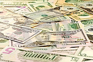 A close-up view of a stack of US five and ten and twenty and fifty dollar bills
