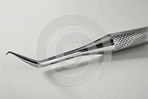 Close-up view of stainless steel dental tool on a white background