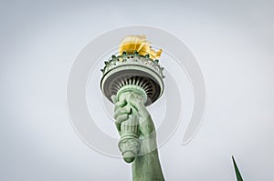 Close Up View of Statue of Liberty Torch Enlightening the World with a Golden Flame in Manhattan, New York City, NY, USA