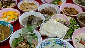 Close-up view of sticky rice, curry, laab, stir-fry and many other dishes packed in bowls