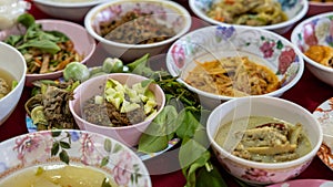 Close-up view of sticky rice, curry, laab, stir-fry and many other dishes packed in bowls