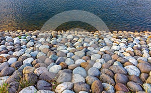 Close-up view of stones of various sizes forming the bank of the Saigawa river which passes through the