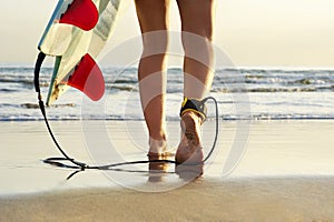 Close up view of surfer walking along beach towards surf