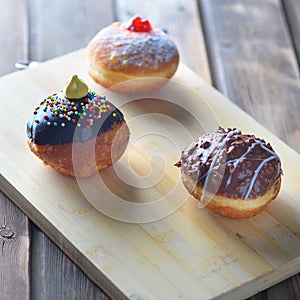 Close up view of tasty various donuts on wood background. Hanukkah celebration concept.