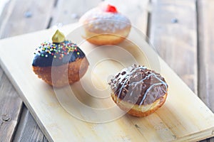 Close up view of tasty various donuts on wood background. Hanukkah celebration concept.