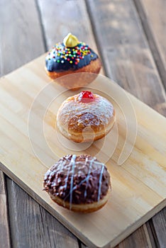 Close up view of tasty various donuts on wood background. Hanukkah celebration concept.