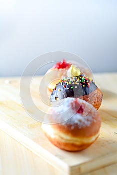 Close up view of tasty various donuts on wood background. Hanukkah celebration concept.