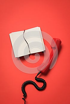 Close-up view of telephone handset and blank open notebook